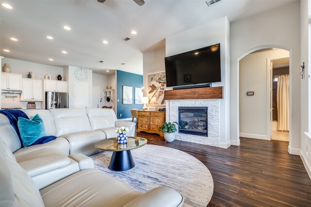 living room featuring a fireplace, dark hardwood / wood-style floors, and ceiling fan