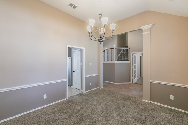 carpeted spare room featuring an inviting chandelier, vaulted ceiling, and decorative columns