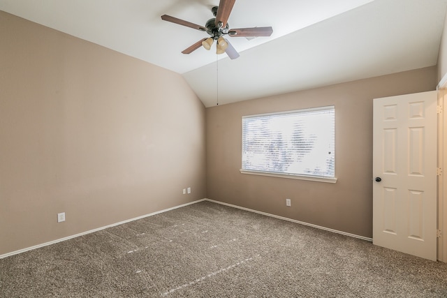 carpeted spare room with ceiling fan and vaulted ceiling