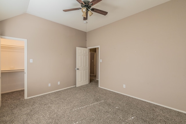 unfurnished bedroom with lofted ceiling, a spacious closet, carpet, and ceiling fan