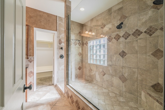 bathroom with tile patterned flooring and tiled shower