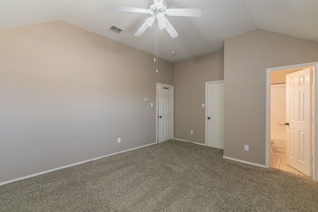 unfurnished bedroom featuring connected bathroom, vaulted ceiling, carpet flooring, and ceiling fan