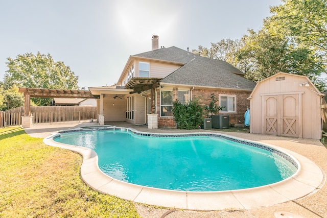 view of pool with a shed, a yard, central air condition unit, a patio area, and a pergola