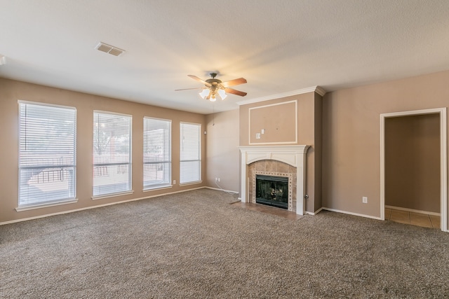 unfurnished living room featuring ceiling fan, plenty of natural light, a tile fireplace, and carpet