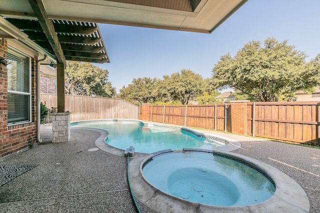 view of swimming pool featuring a patio and an in ground hot tub