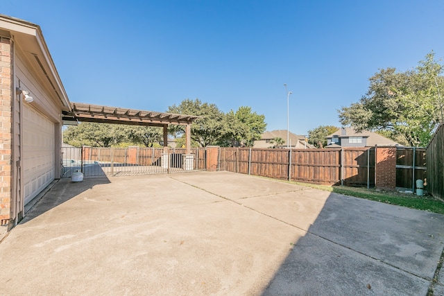 view of patio / terrace with a garage and a pergola