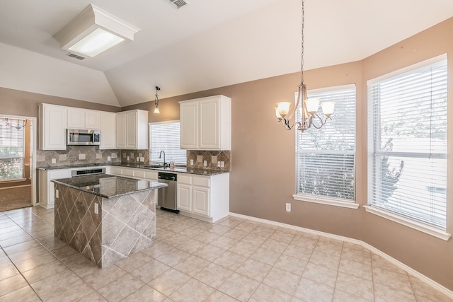 kitchen featuring pendant lighting, appliances with stainless steel finishes, vaulted ceiling, and plenty of natural light