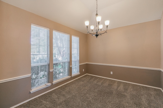 carpeted spare room featuring a chandelier