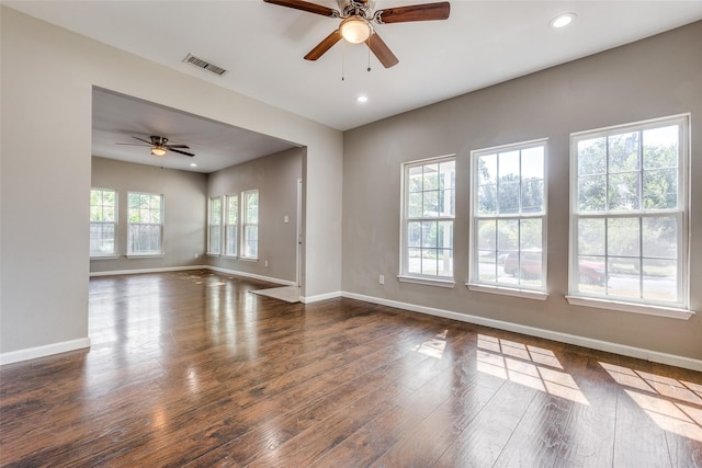 unfurnished room with ceiling fan, a wealth of natural light, and dark hardwood / wood-style floors