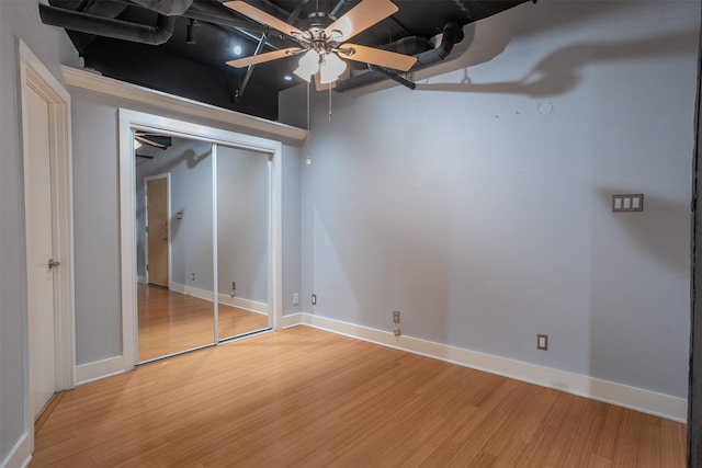 basement featuring light wood-type flooring and ceiling fan