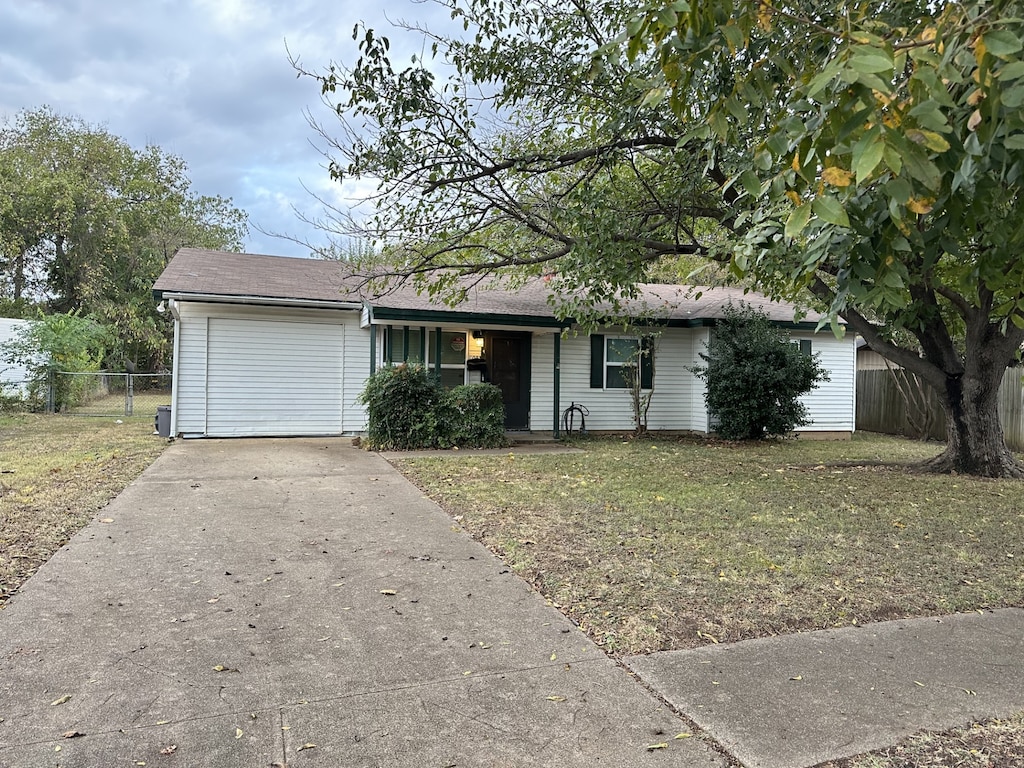 ranch-style house featuring a garage and a front yard