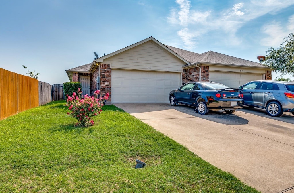 ranch-style home with a garage and a front yard