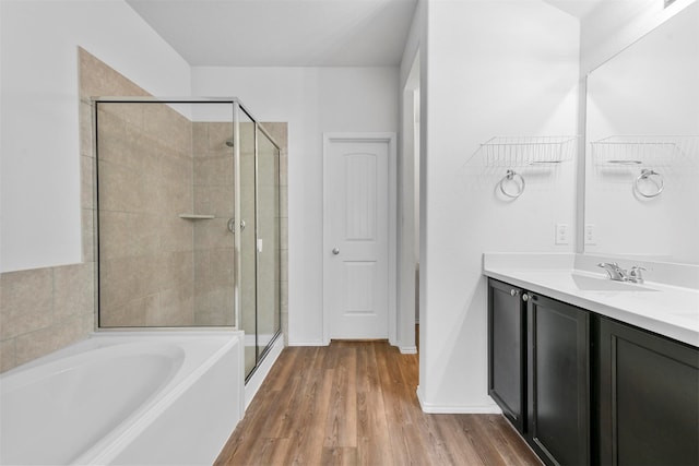 bathroom featuring hardwood / wood-style flooring, vanity, and shower with separate bathtub