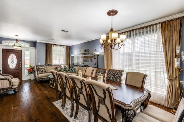 dining space featuring a notable chandelier, dark hardwood / wood-style flooring, and ornamental molding