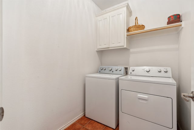 laundry room with washing machine and clothes dryer, cabinets, and tile patterned flooring