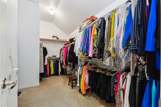 walk in closet featuring light carpet and vaulted ceiling