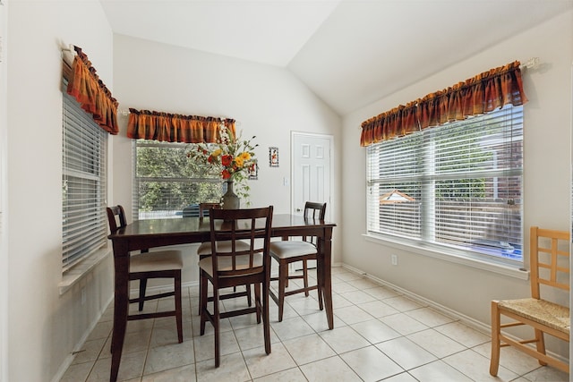 dining space with vaulted ceiling and light tile patterned floors