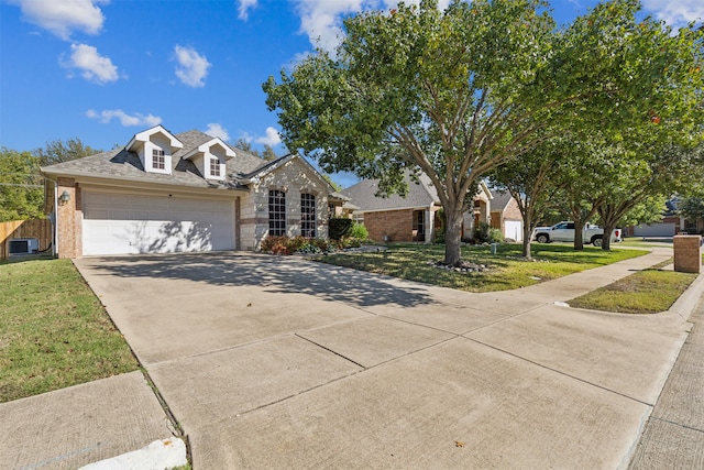 view of front of property with central air condition unit, a garage, and a front yard