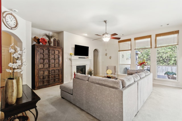 carpeted living room with ceiling fan