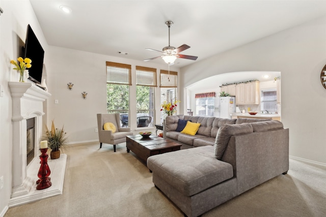 carpeted living room featuring ceiling fan