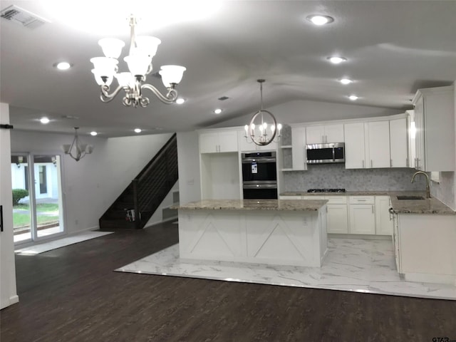 kitchen with stainless steel appliances, hanging light fixtures, white cabinetry, and a center island