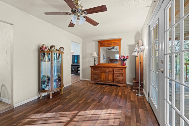 interior space with ceiling fan, dark hardwood / wood-style floors, a textured ceiling, and french doors