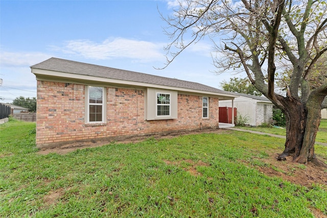 view of front of property featuring a front yard and a shed