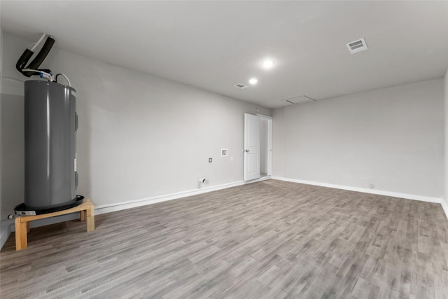 unfurnished living room featuring light hardwood / wood-style floors and water heater