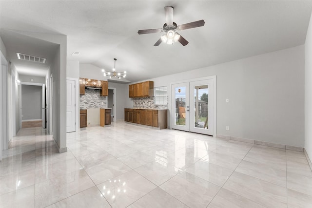 unfurnished living room featuring ceiling fan with notable chandelier and lofted ceiling