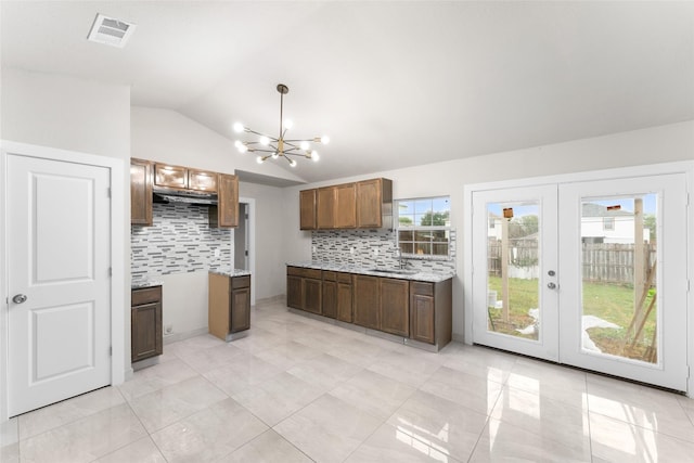 kitchen with sink, decorative backsplash, lofted ceiling, and french doors