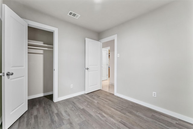 unfurnished bedroom featuring a closet and wood-type flooring