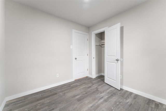 unfurnished bedroom with wood-type flooring and a closet