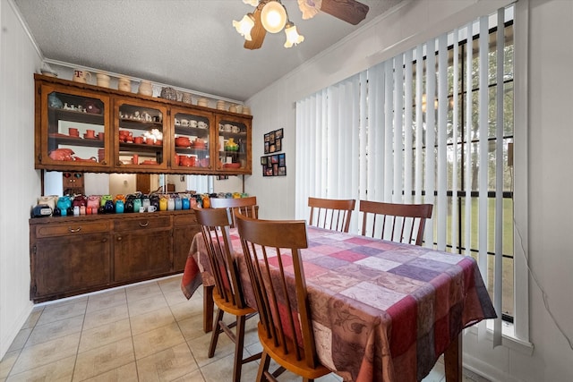 dining area with ceiling fan, ornamental molding, a textured ceiling, and light tile patterned floors