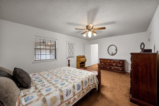 carpeted bedroom with ceiling fan and a textured ceiling