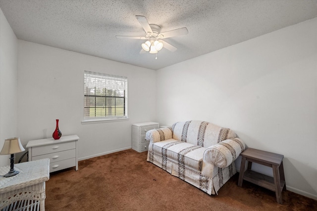 sitting room featuring ceiling fan, dark carpet, and a textured ceiling