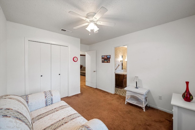 living area with a textured ceiling, ceiling fan, and carpet