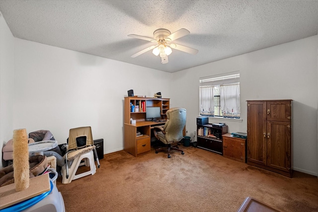 carpeted office space with a textured ceiling and ceiling fan