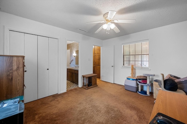 interior space featuring ensuite bathroom, ceiling fan, and a textured ceiling