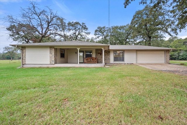 ranch-style house featuring a garage, a front lawn, and covered porch