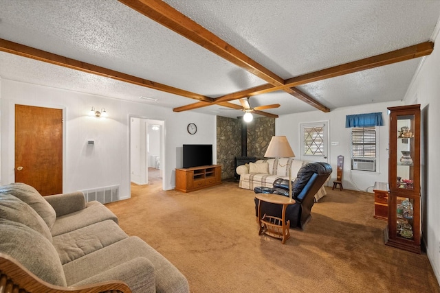 carpeted living room featuring a wood stove, a textured ceiling, and beam ceiling