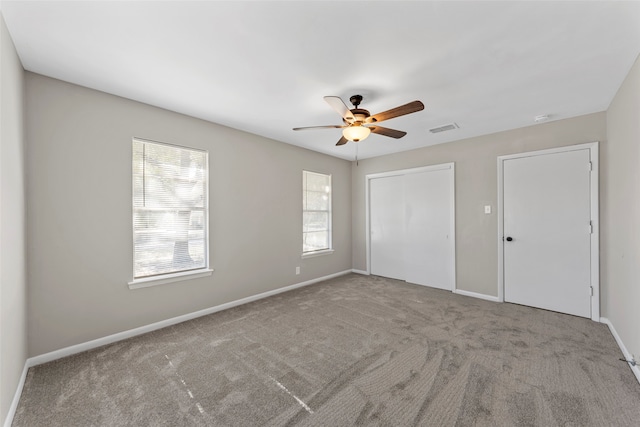 unfurnished bedroom with ceiling fan and light carpet