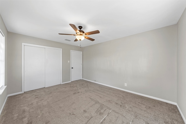 unfurnished bedroom with carpet, multiple windows, and ceiling fan