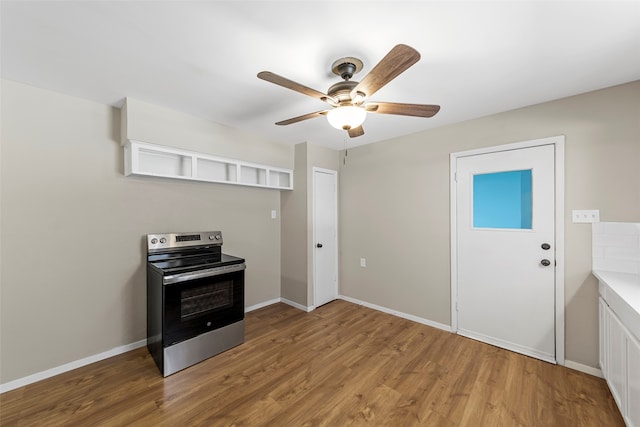 kitchen featuring electric stove, ceiling fan, and hardwood / wood-style flooring