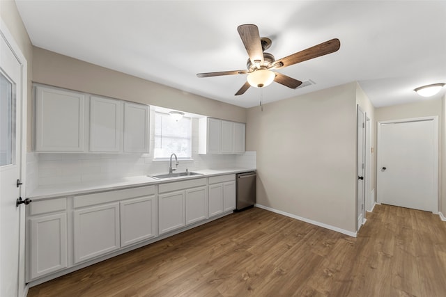 kitchen featuring dishwasher, white cabinets, sink, tasteful backsplash, and light hardwood / wood-style floors