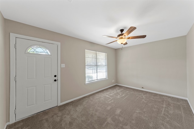 carpeted entrance foyer featuring ceiling fan and a healthy amount of sunlight