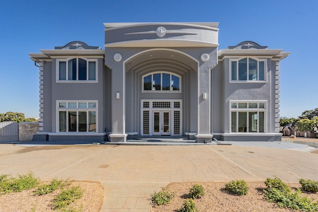 rear view of house with french doors and stucco siding