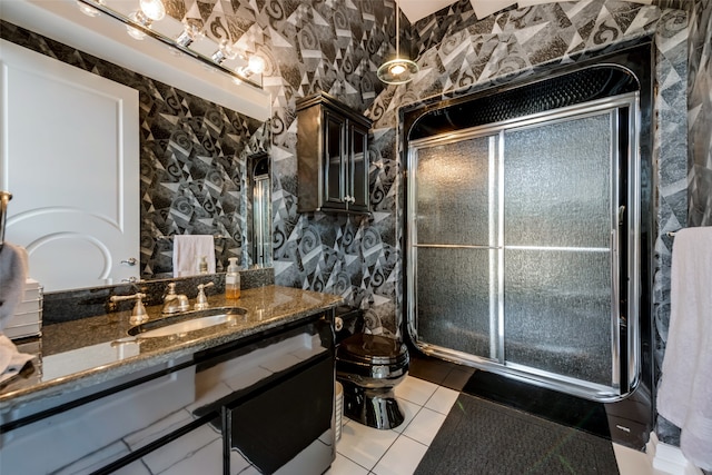 bathroom featuring toilet, vanity, tile patterned floors, and a shower with shower door