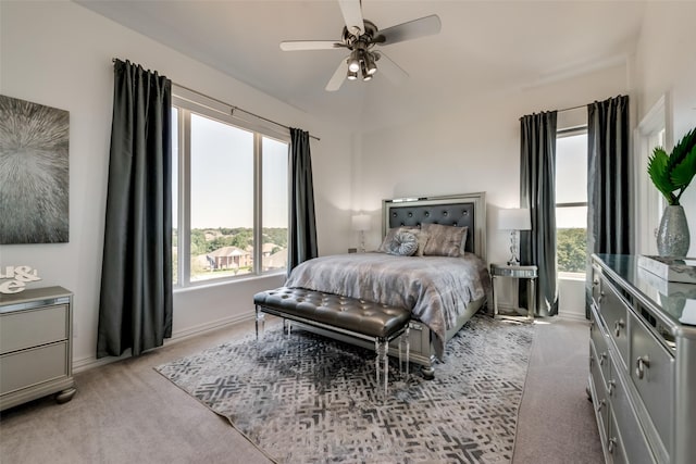 bedroom featuring light carpet, baseboards, and a ceiling fan