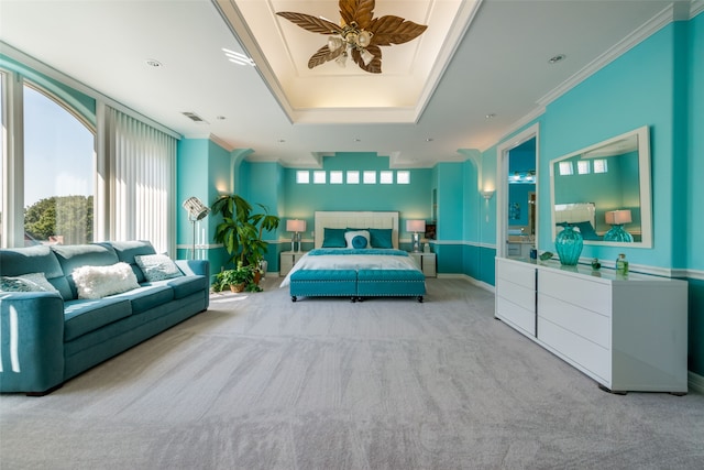 carpeted bedroom with ceiling fan, a raised ceiling, and crown molding