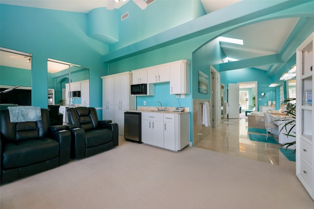 kitchen featuring white cabinetry, high vaulted ceiling, and light carpet